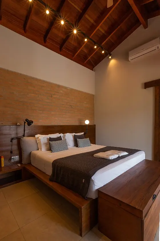 Quarto com forro de madeira e parede de tijolinho