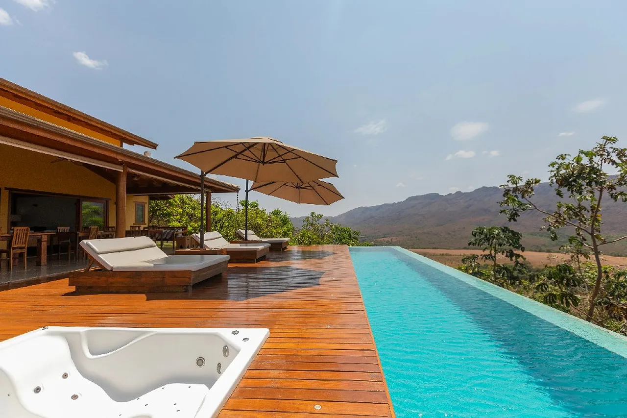 Piscina de borda infinita da Zandaia Eco Pousada sobre o vale e a Serra da Canastra ao entardecer